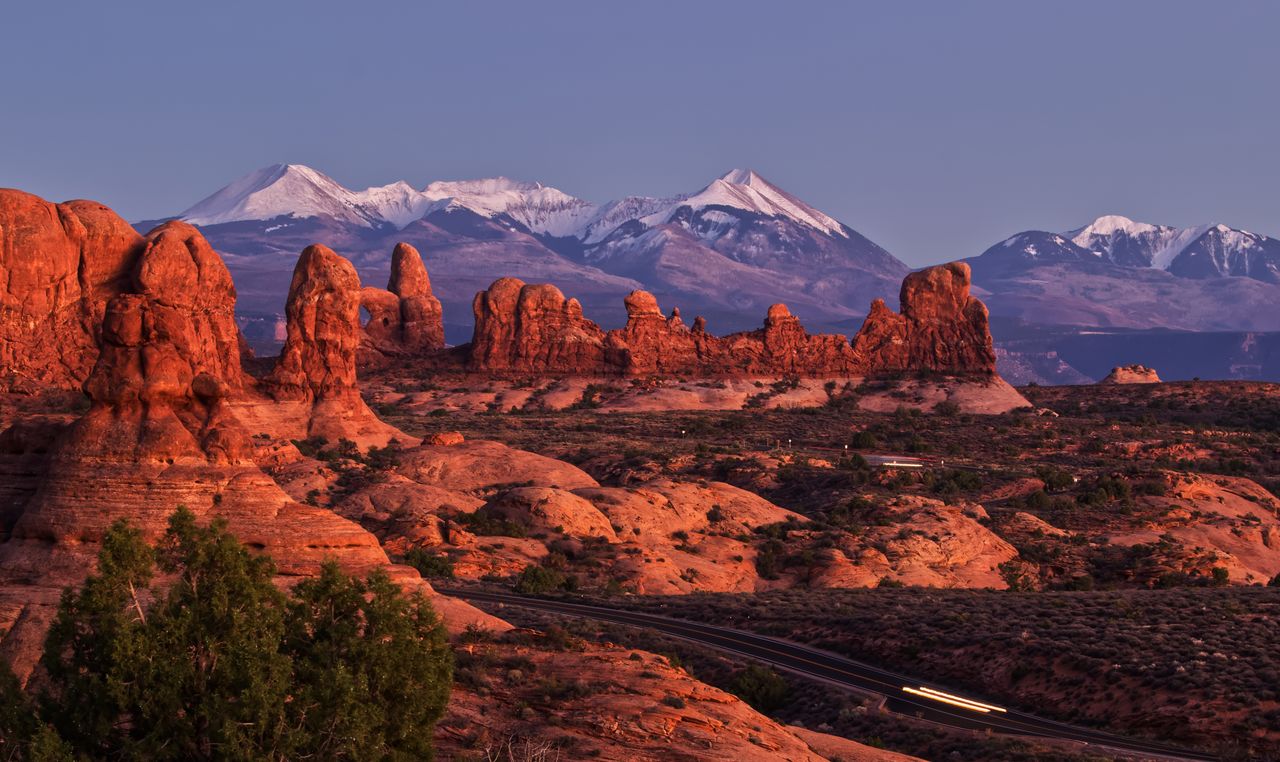 Crafting Captivating Headlines: Your awesome post title goes here Stunning view of red rock formations and snow-capped peaks during sunset in Utah's Arches National Park.
